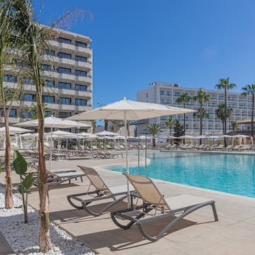 a pool with lounge chairs and umbrellas