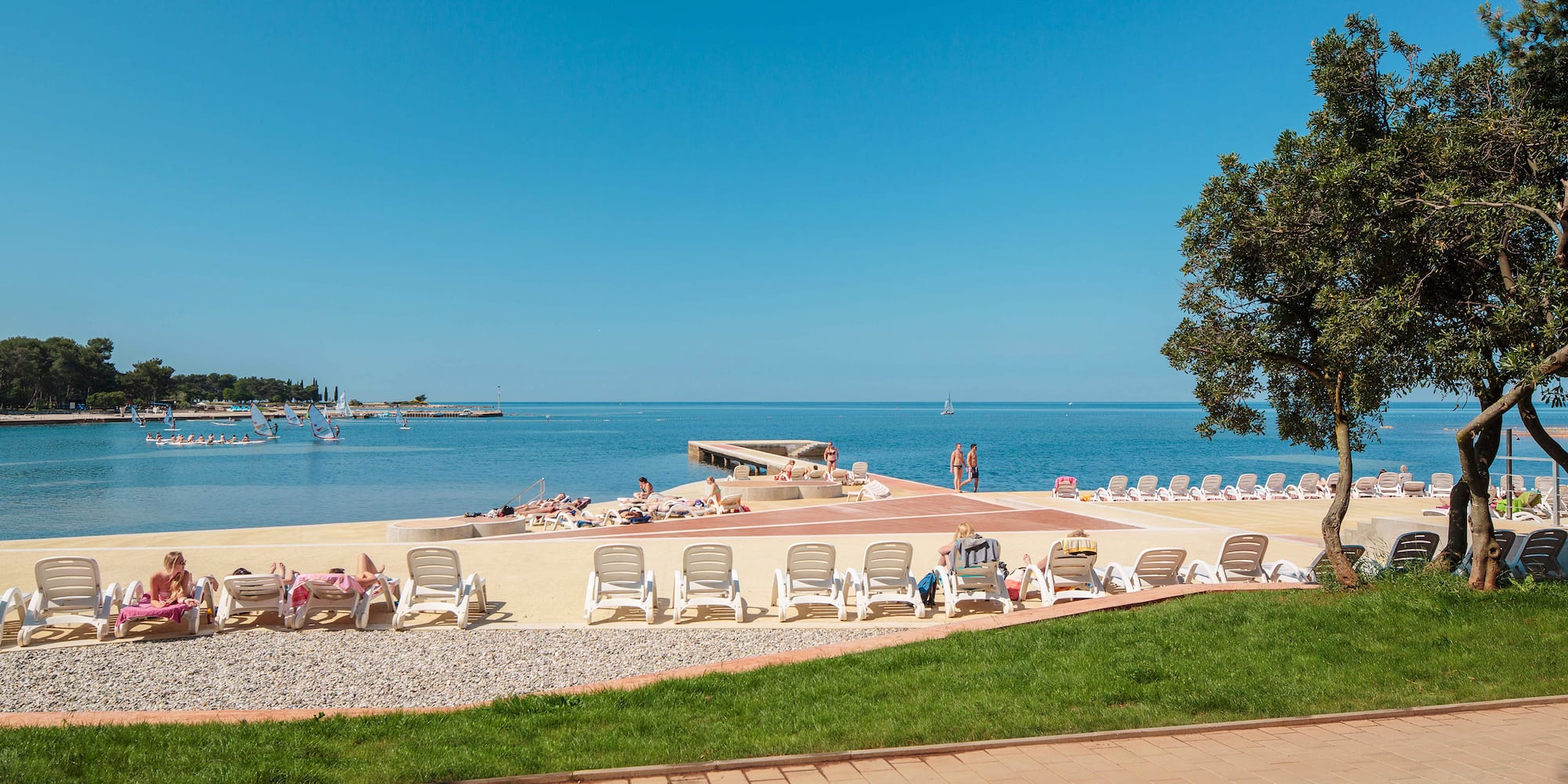 a beach with chairs and a body of water