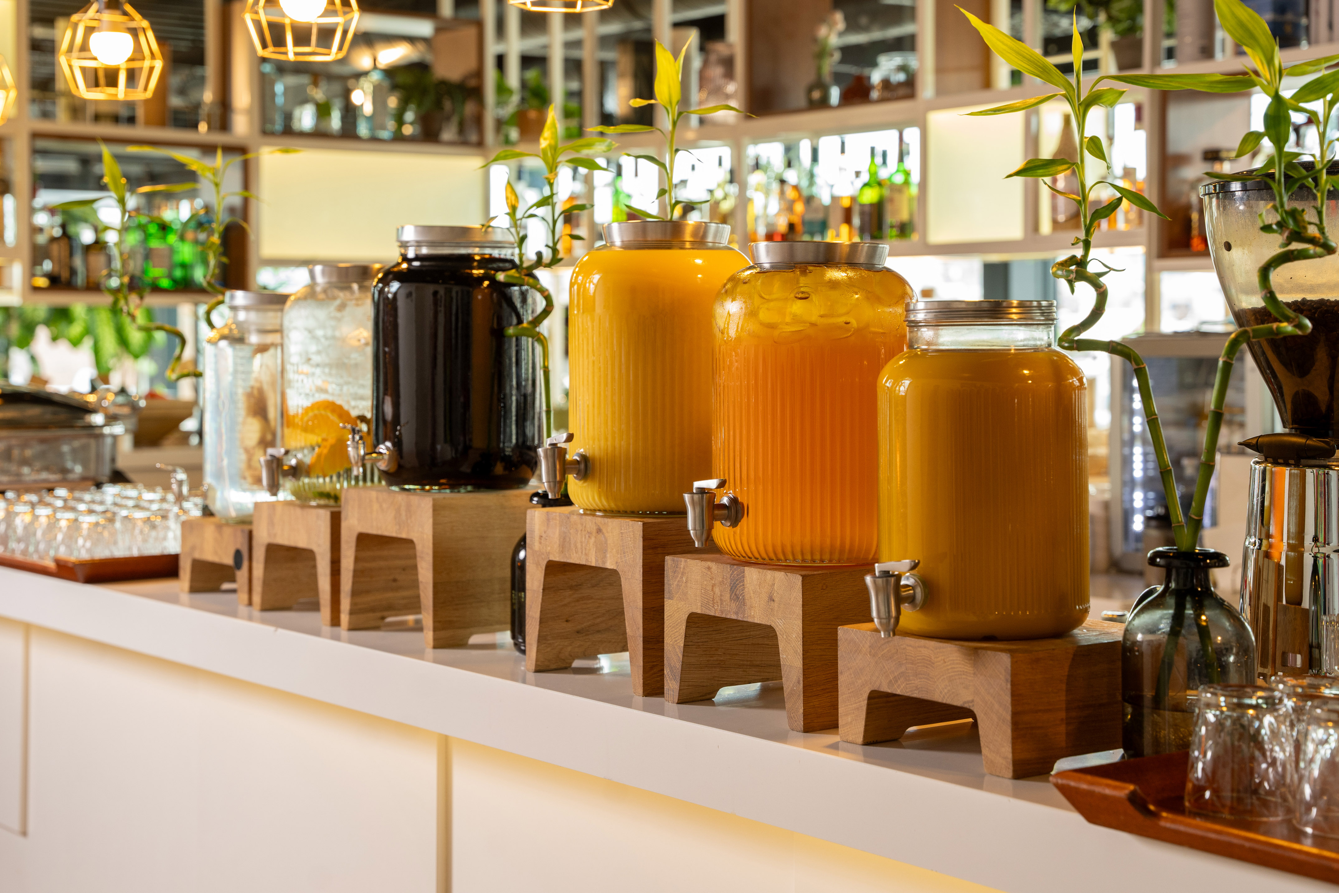 Buffet beverage station featuring juice and water dispensers on a modern counter.