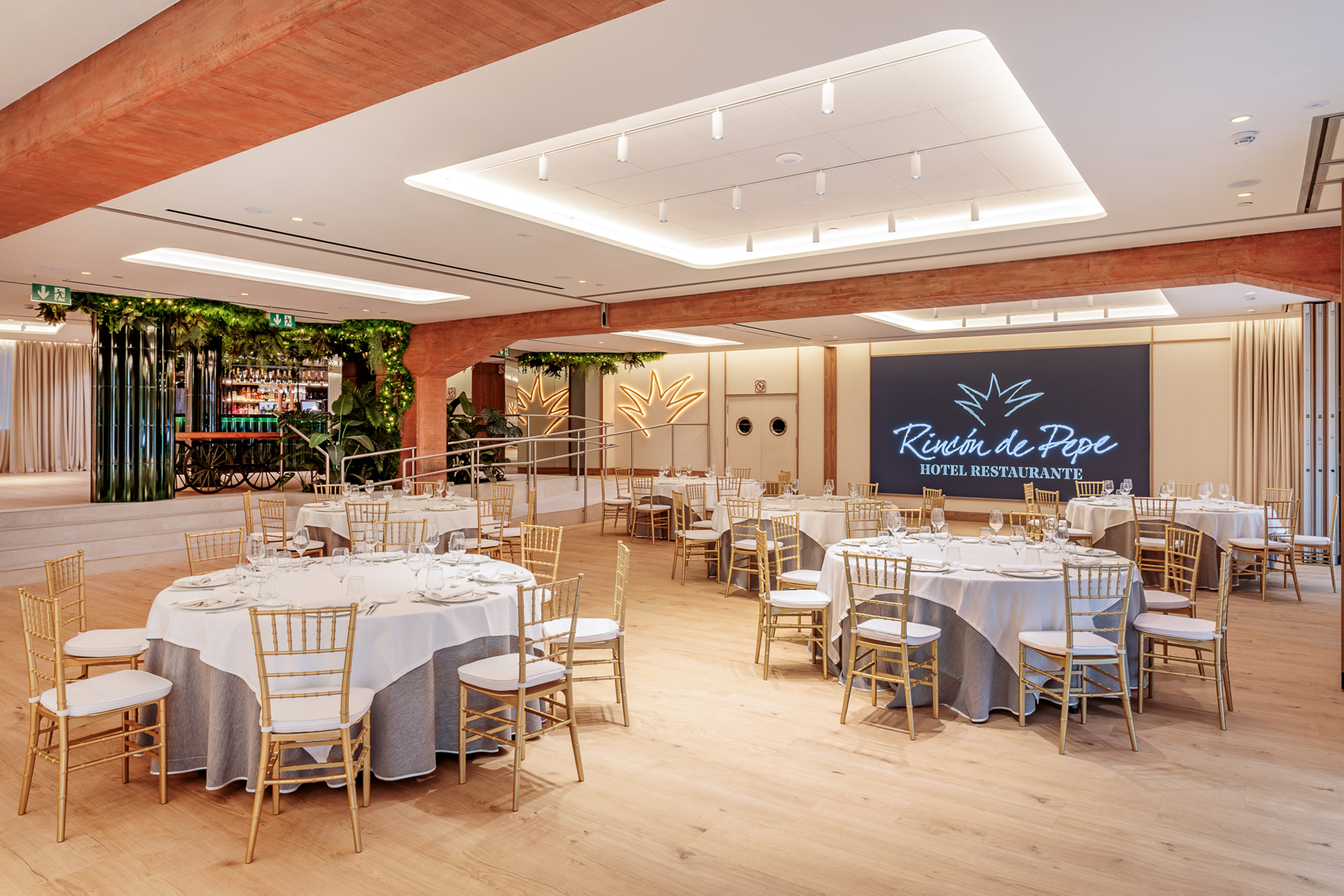 Rincón de Pepe restaurant banquet hall with set tables and golden chairs.