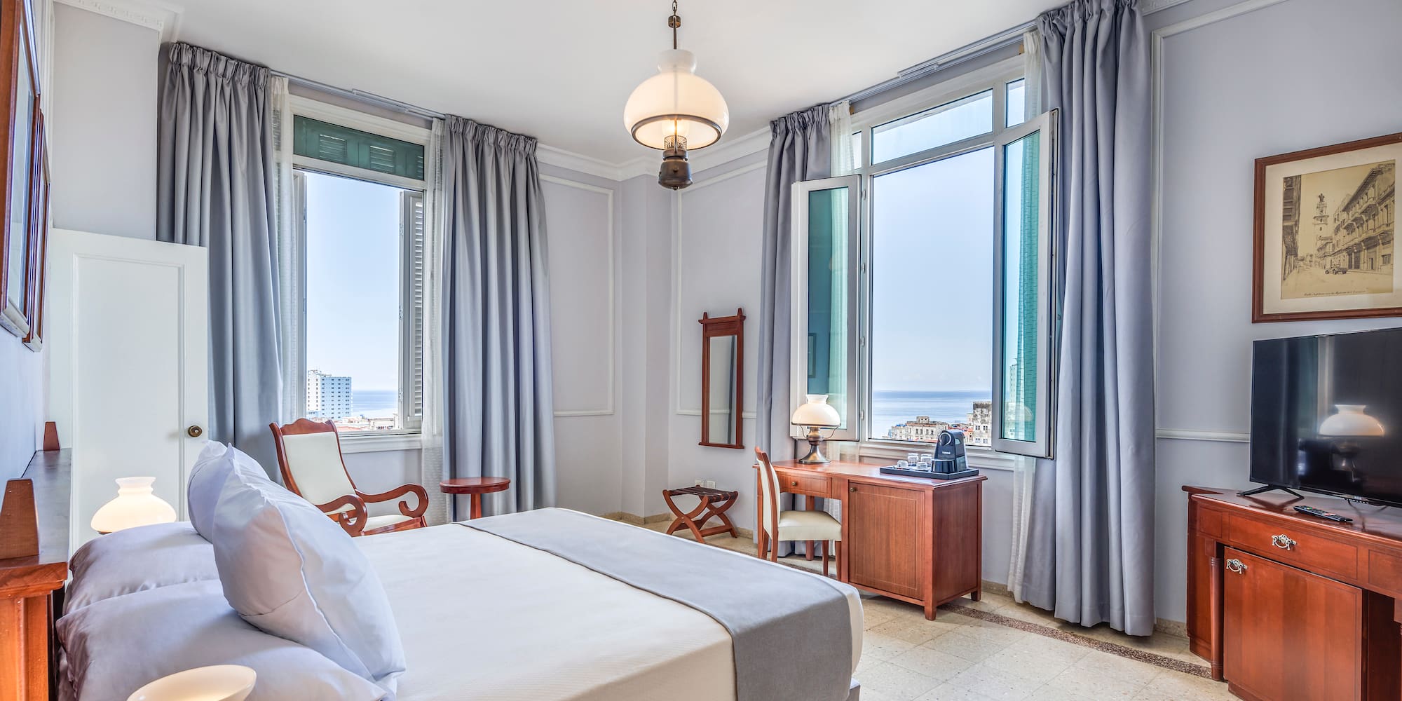 a bedroom with a bed and a desk and chairs