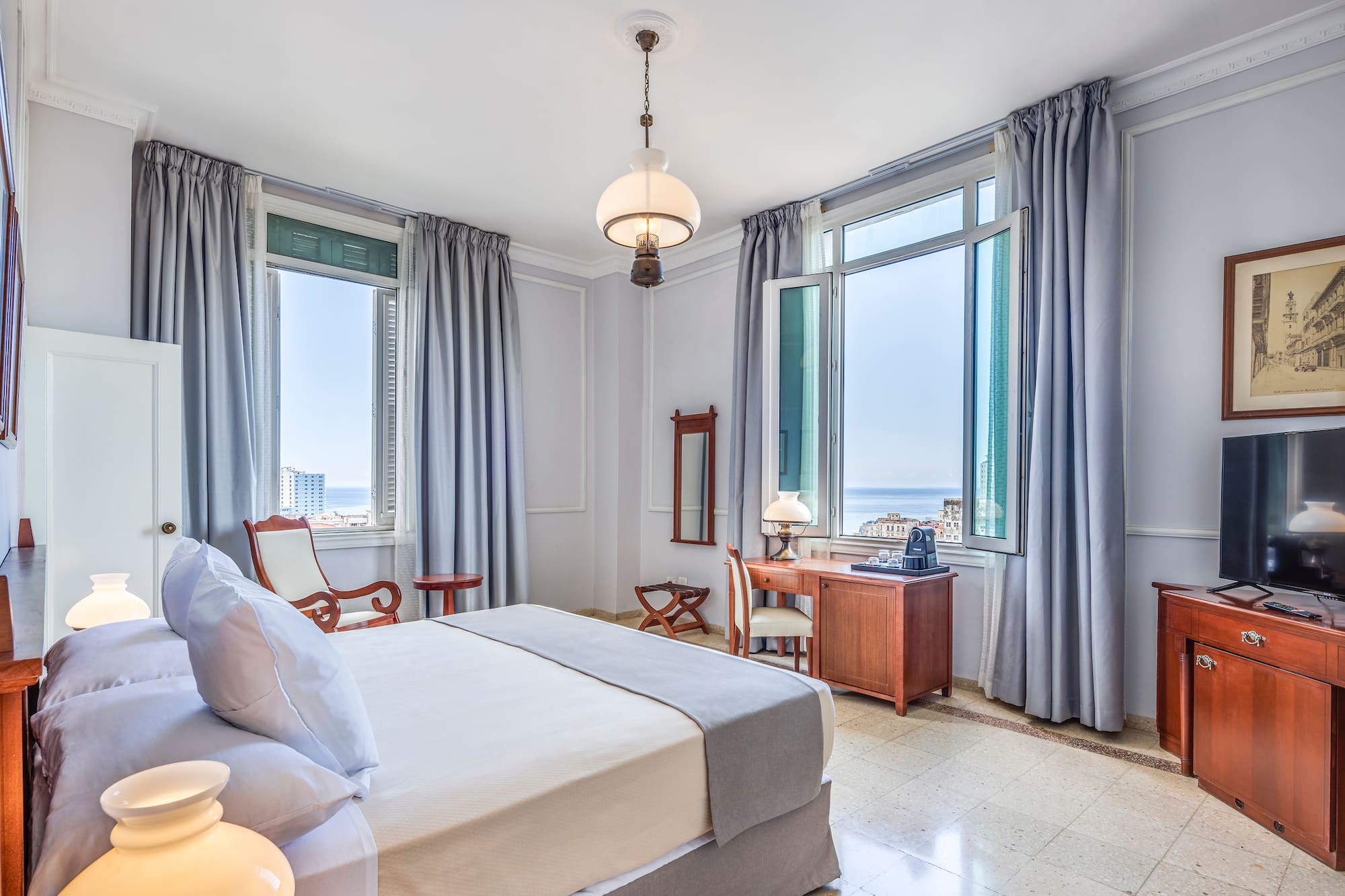 a bedroom with a bed and a desk and chairs