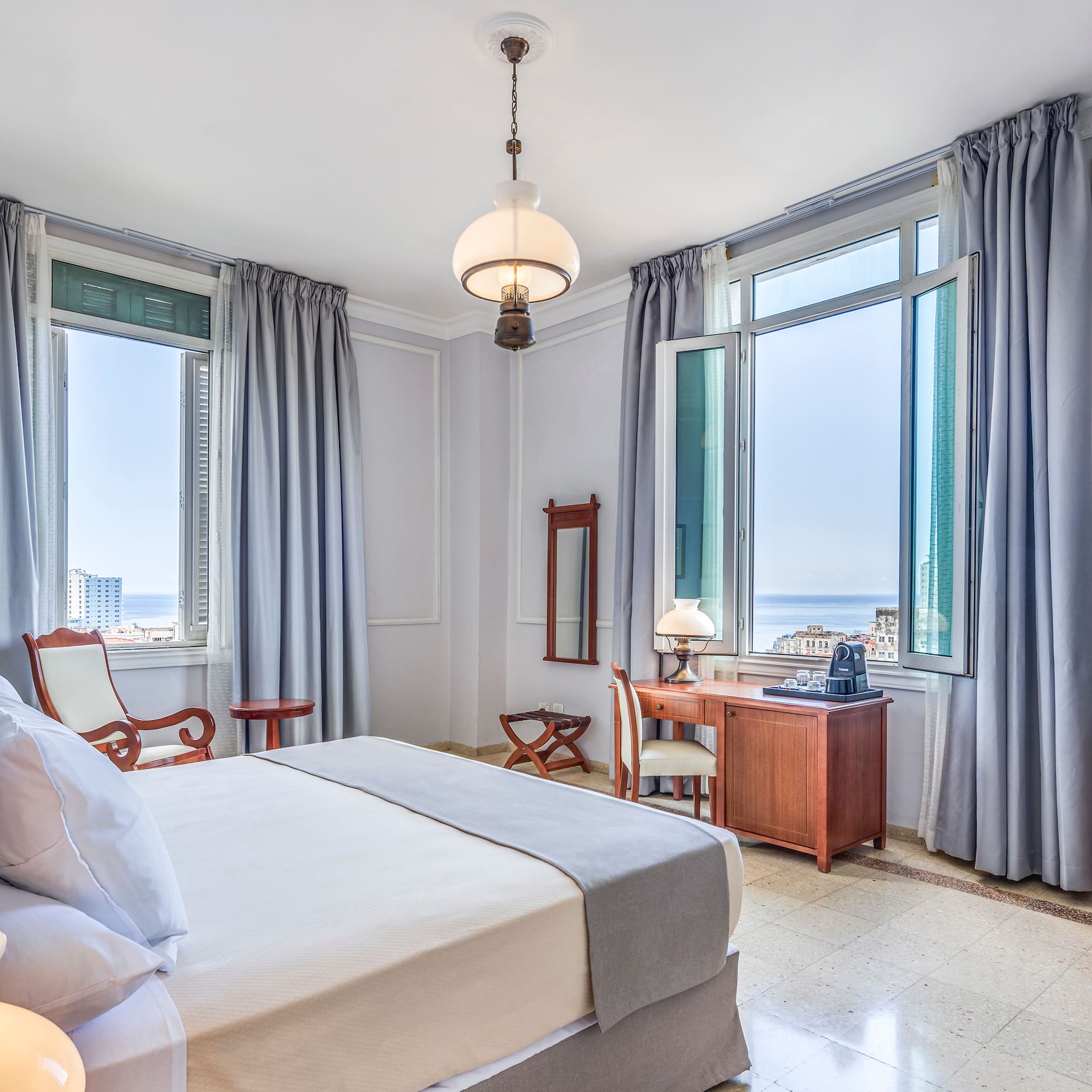 a bedroom with a bed and a desk and chairs