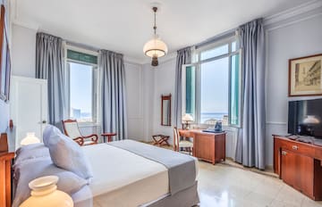 a bedroom with a bed and a desk and chairs