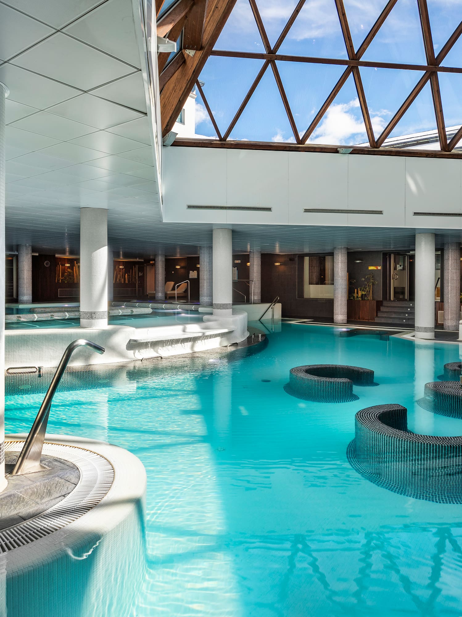 a large indoor pool with a glass roof