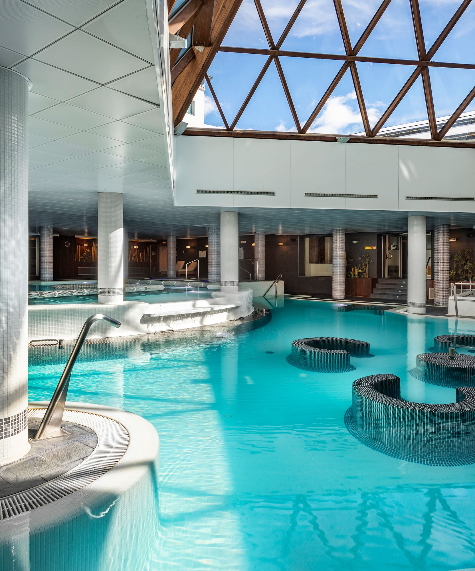 a large indoor pool with a glass roof