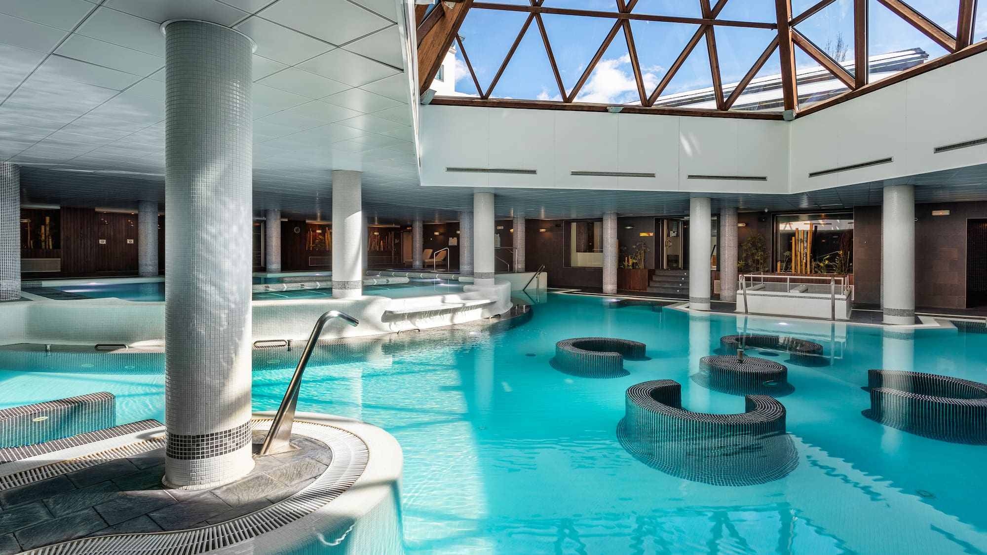 a large indoor pool with a glass roof