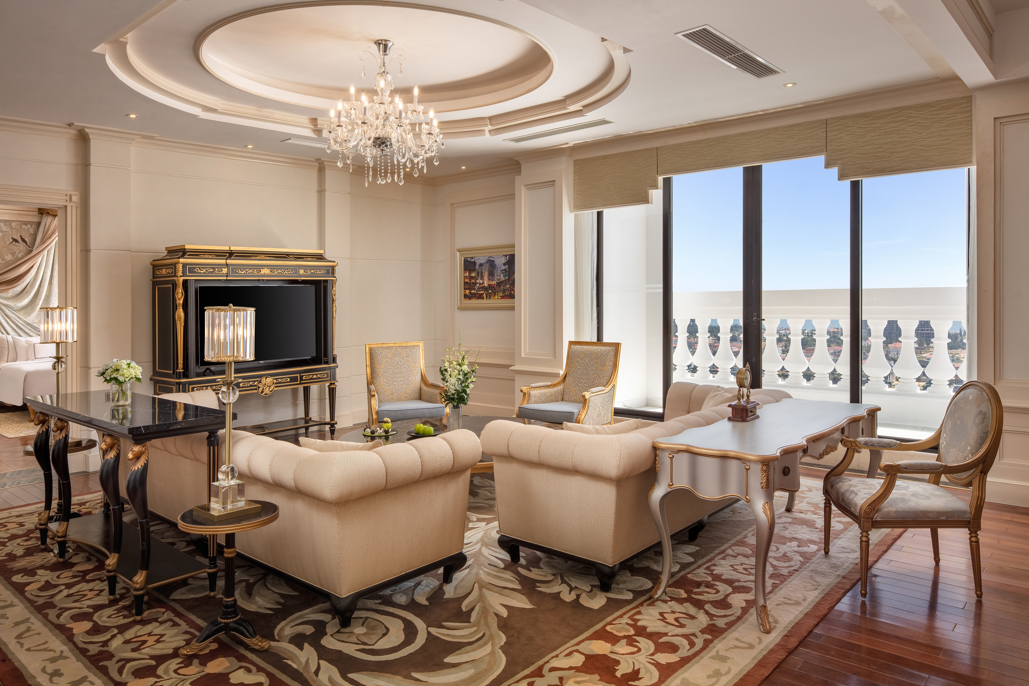 Luxurious living room with elegant furniture, crystal chandelier, and balcony view.