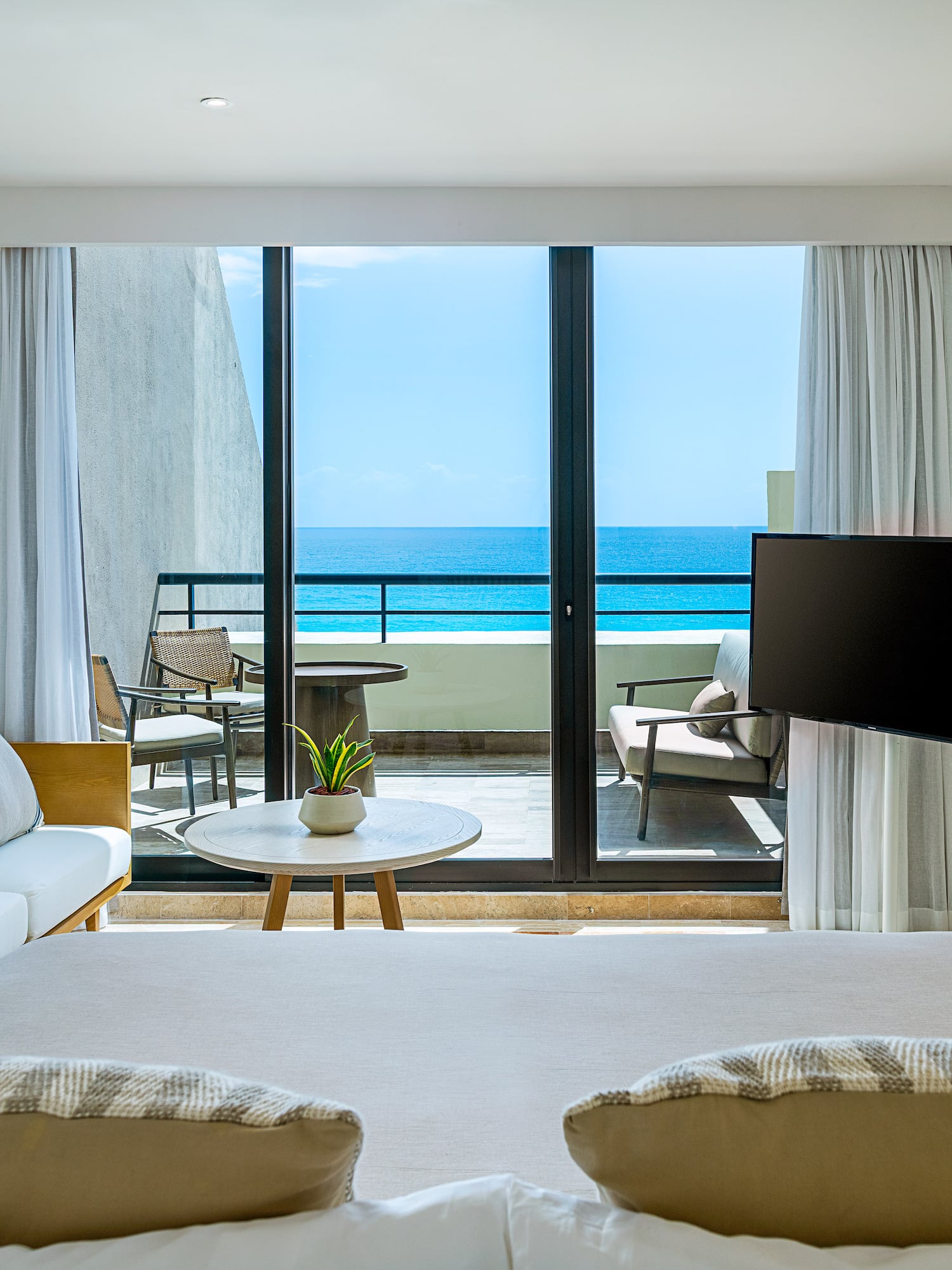 a room with a television and a view of the ocean