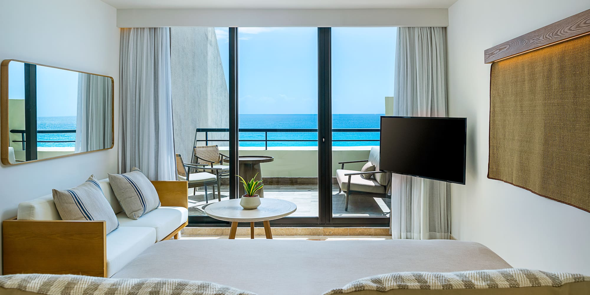 a room with a television and a view of the ocean