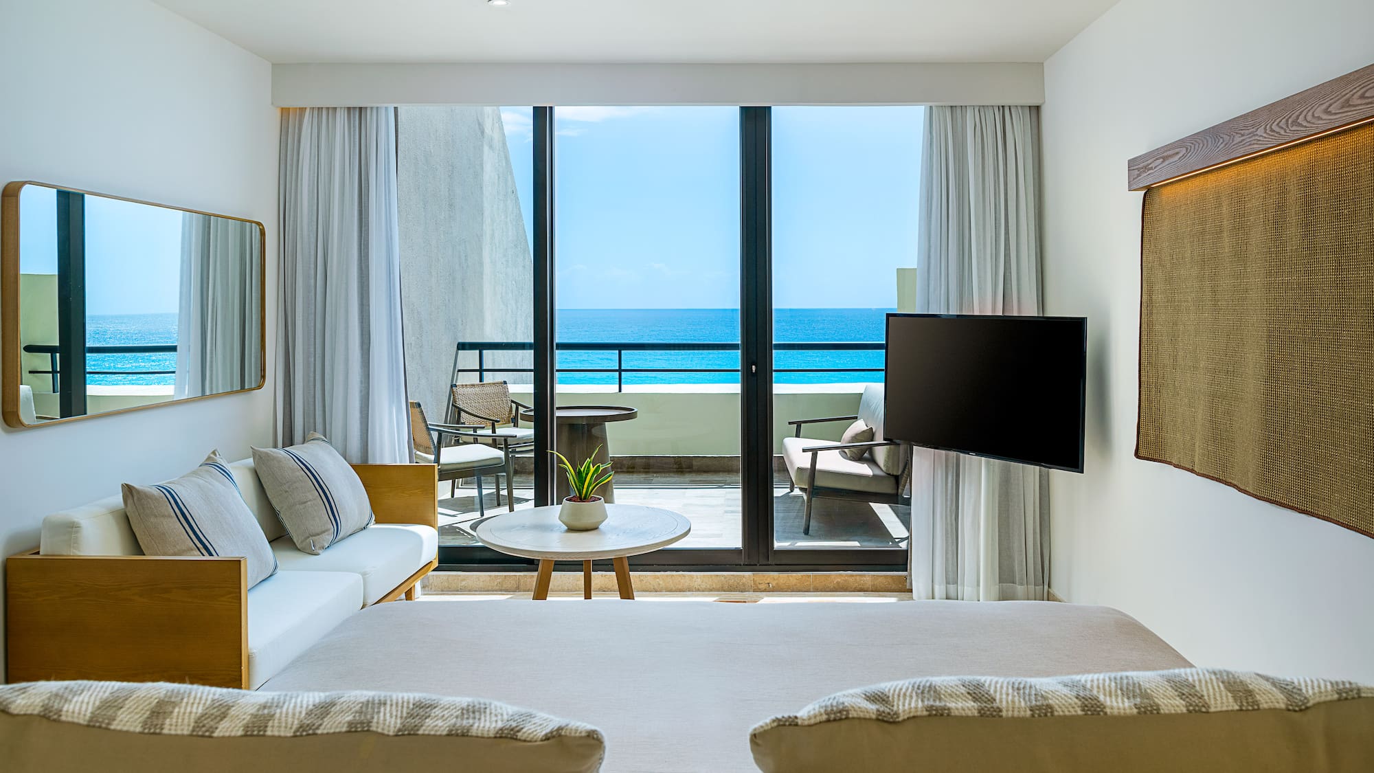 a room with a television and a view of the ocean