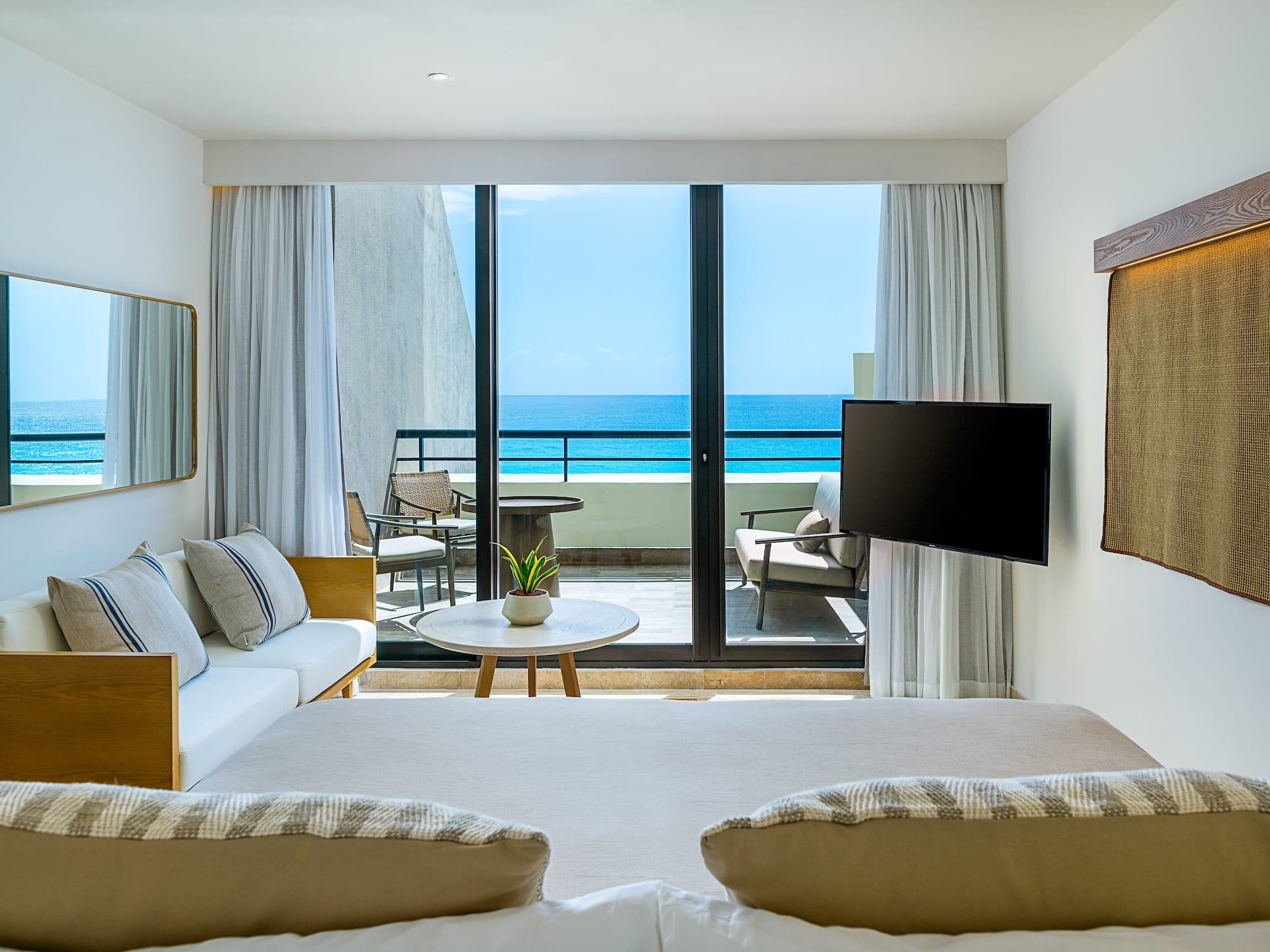 a room with a television and a view of the ocean