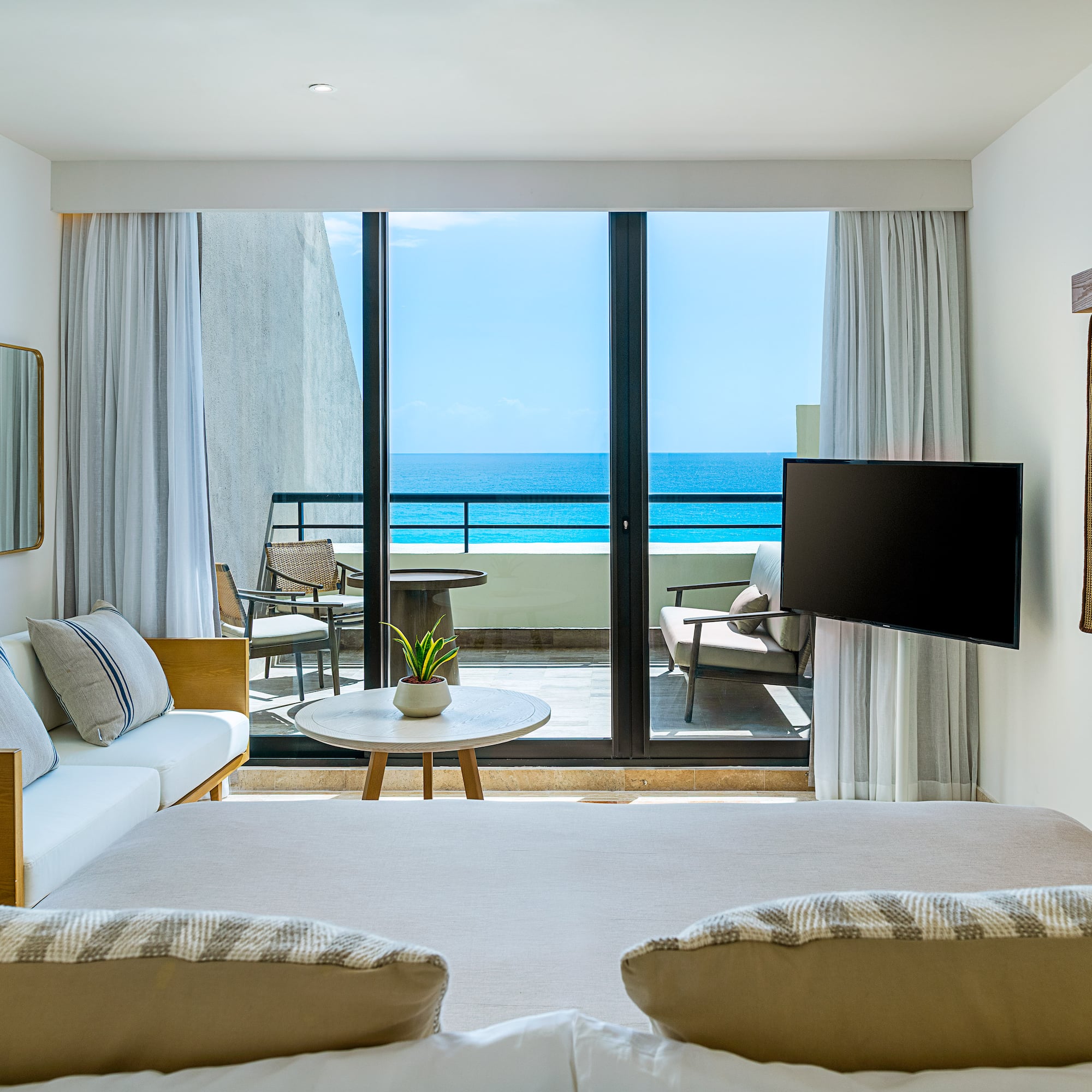a room with a television and a view of the ocean