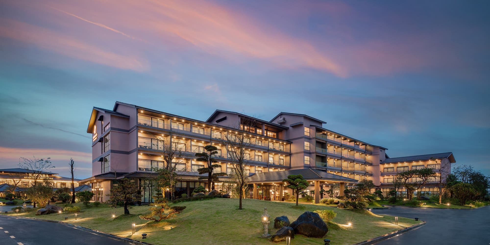 a large building with a lawn and trees