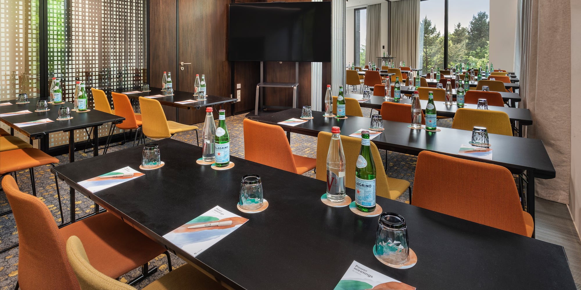 a room with tables and chairs and a television