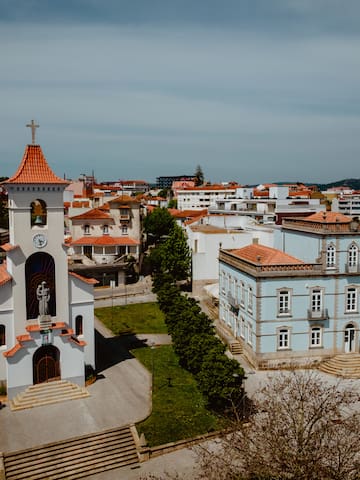 a white building with a bell tower and a green lawn