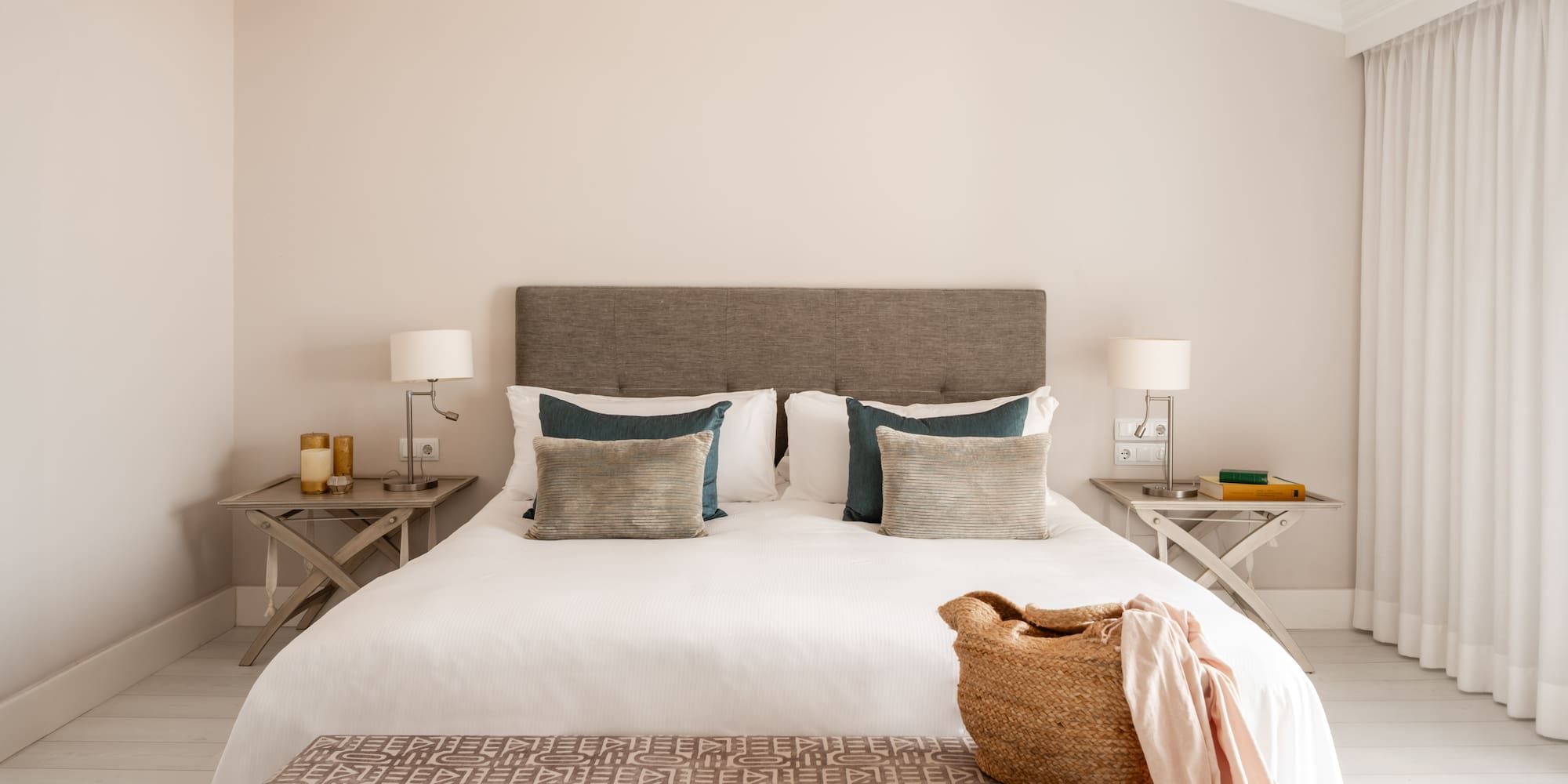 a bed with pillows and a basket on top of it