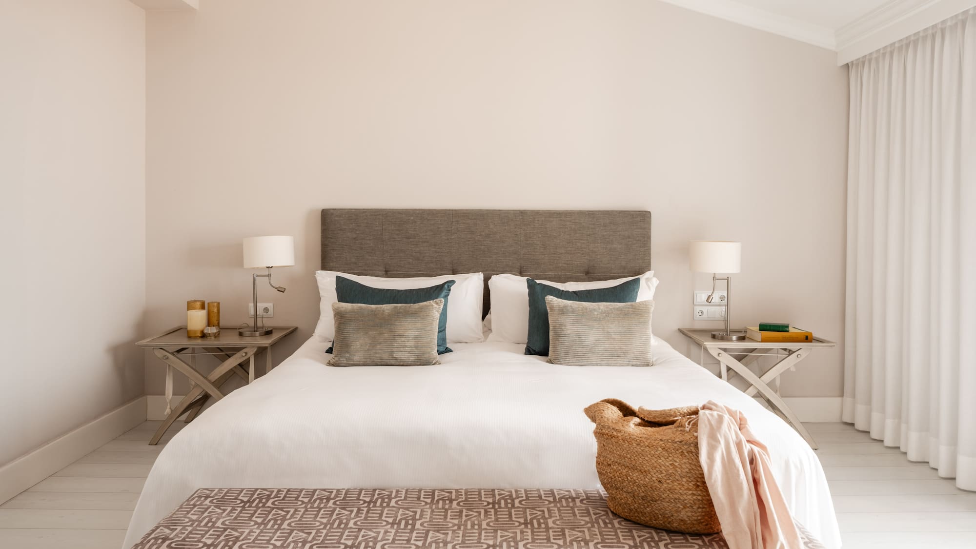 a bed with pillows and a basket on top of it