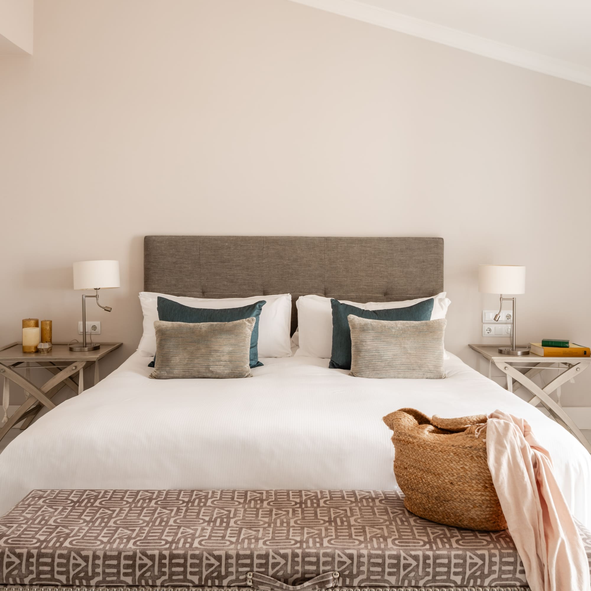 a bed with pillows and a basket on top of it