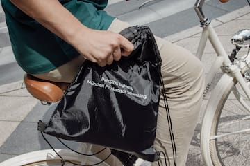 a person on a bicycle holding a bag