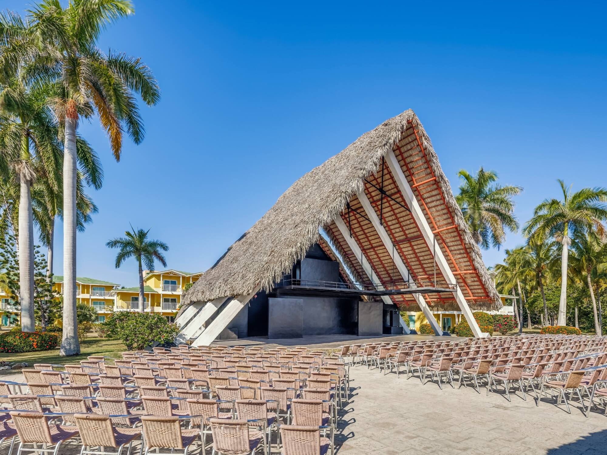 a building with chairs and a thatched roof