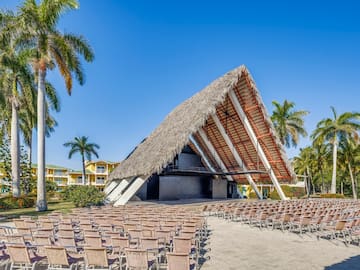 a building with chairs and a thatched roof