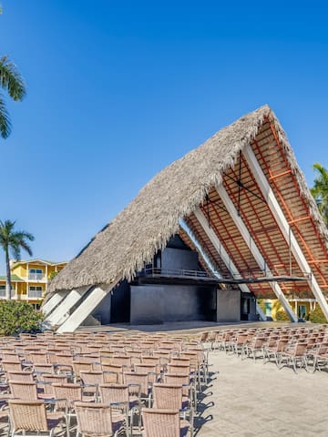 a building with chairs and a thatched roof