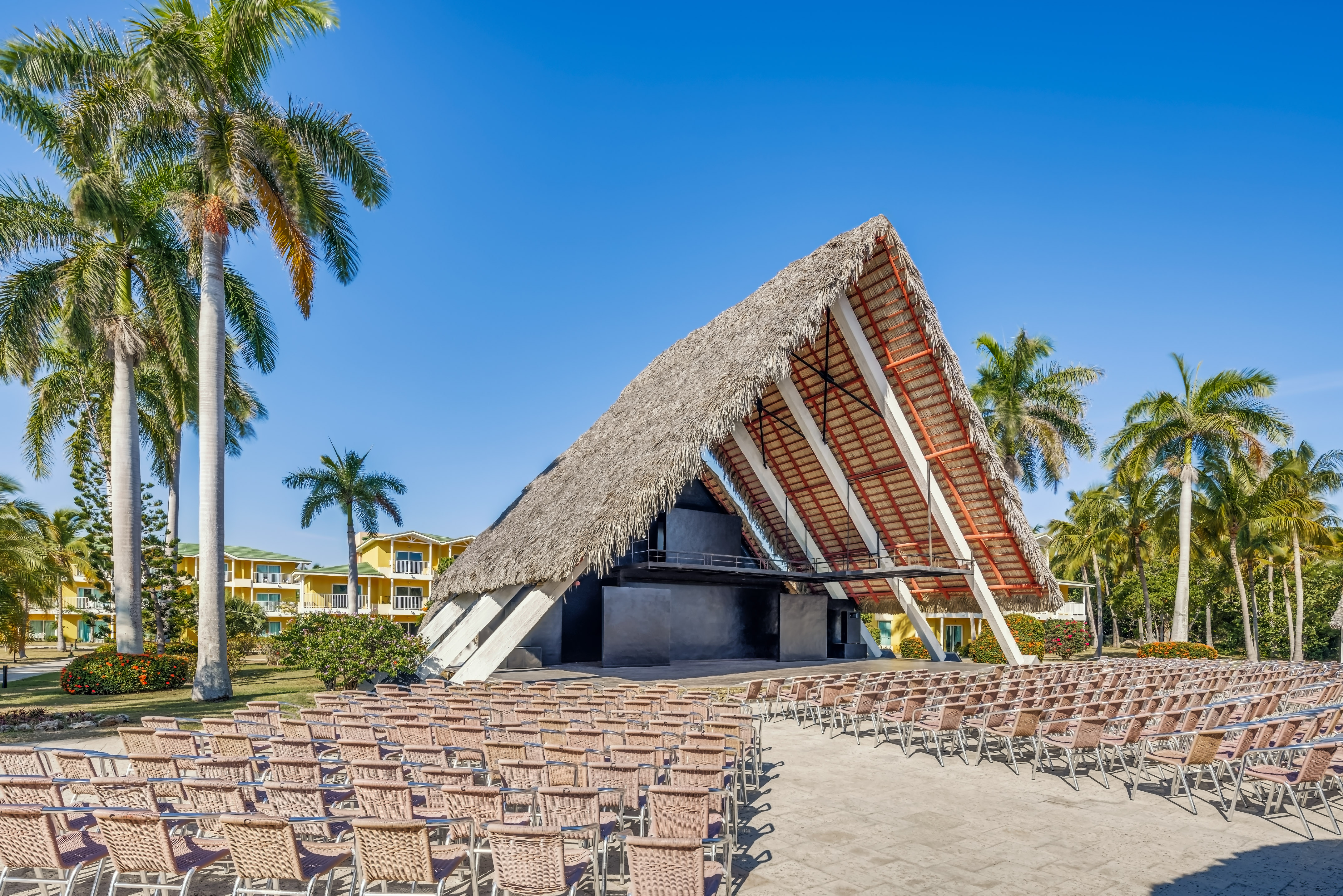 a building with chairs and a thatched roof