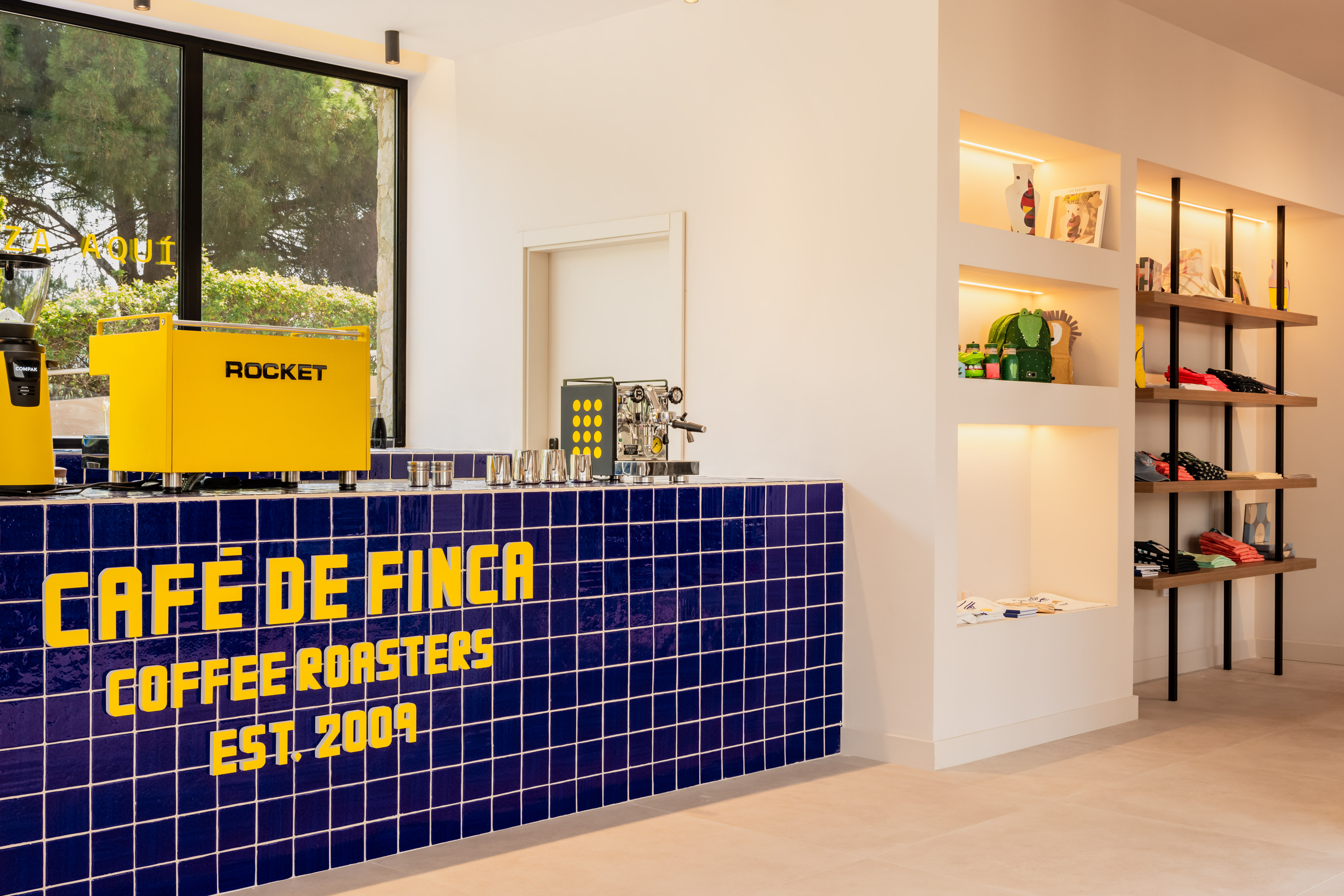 Cafe de Finca coffee roasters cafe, blue tiled counter, yellow espresso machine.
