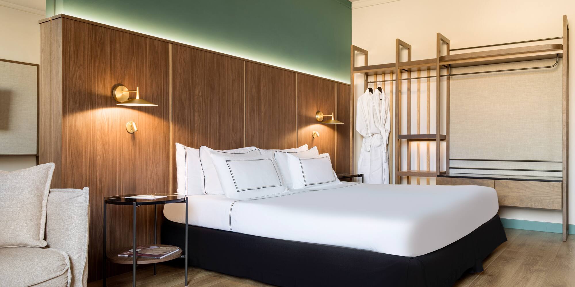 a bed with white sheets and a wood paneled wall