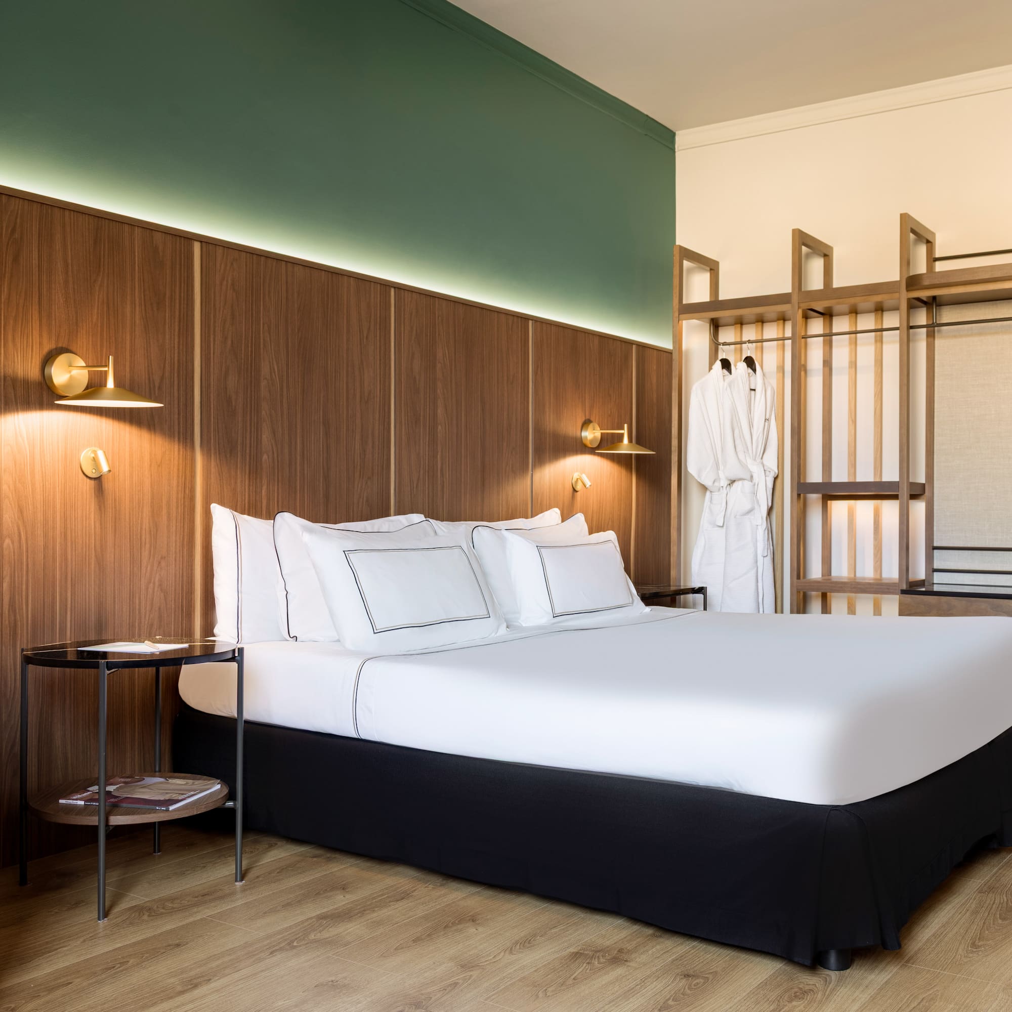a bed with white sheets and a wood paneled wall