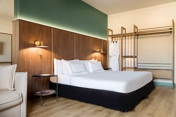 a bed with white sheets and a wood paneled wall