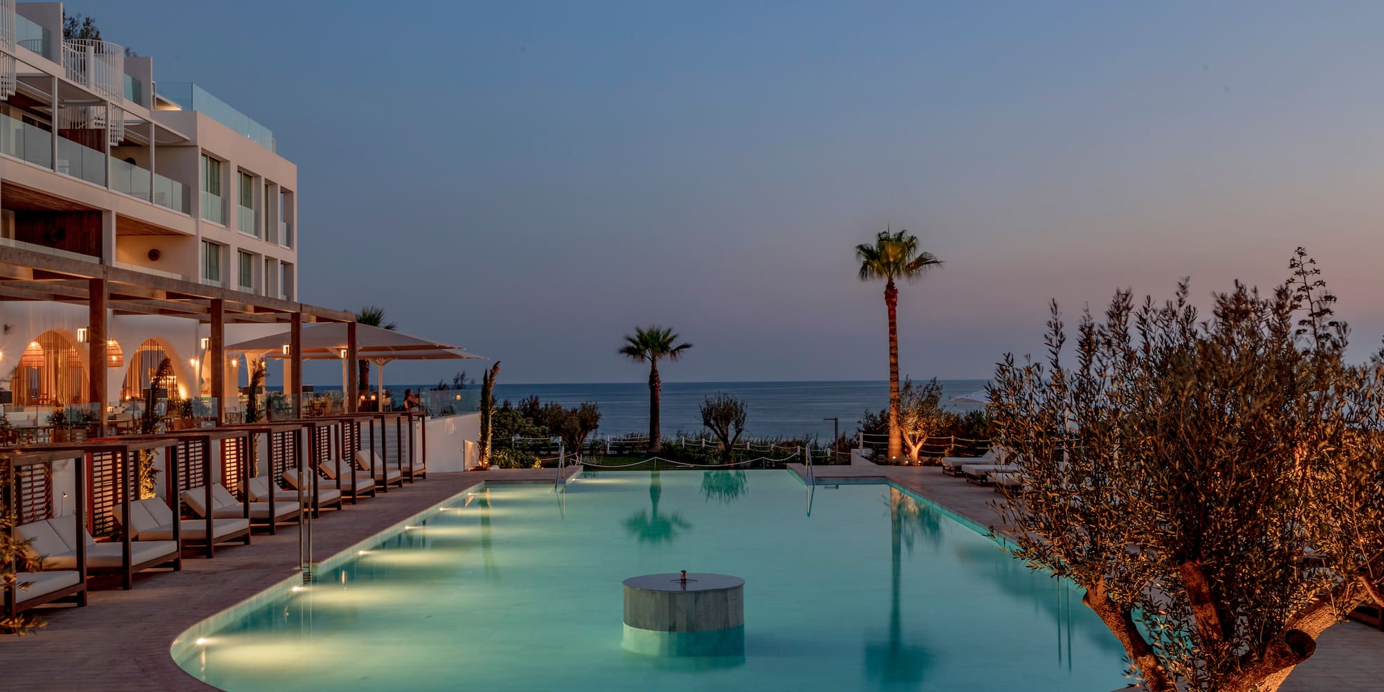 a pool with a building and palm trees