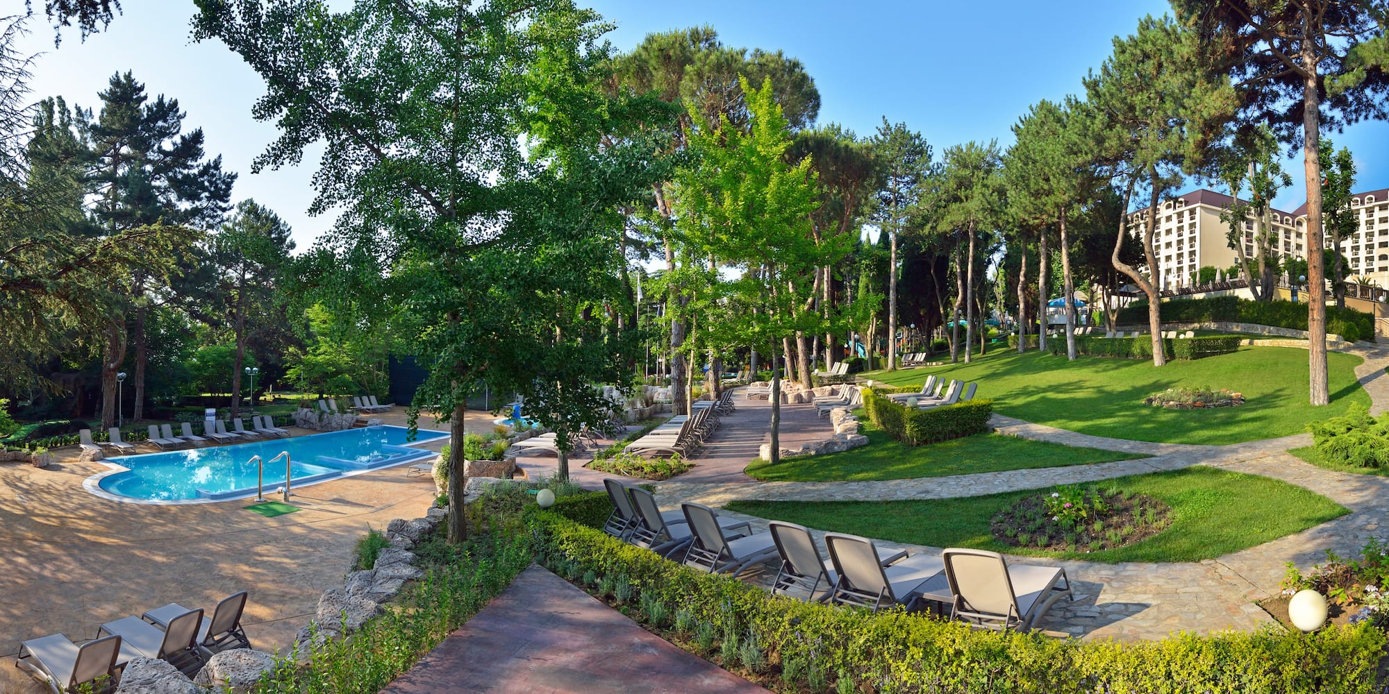 a pool with lawn chairs and trees