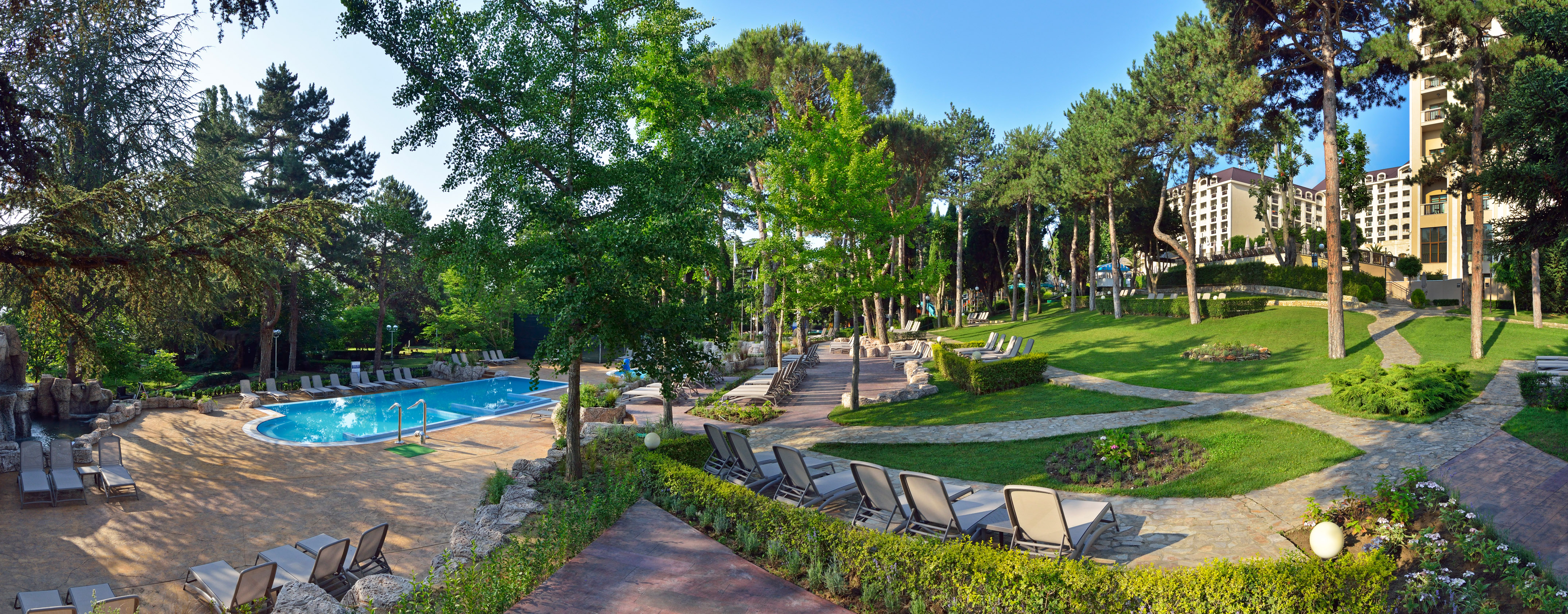 a pool with lawn chairs and trees