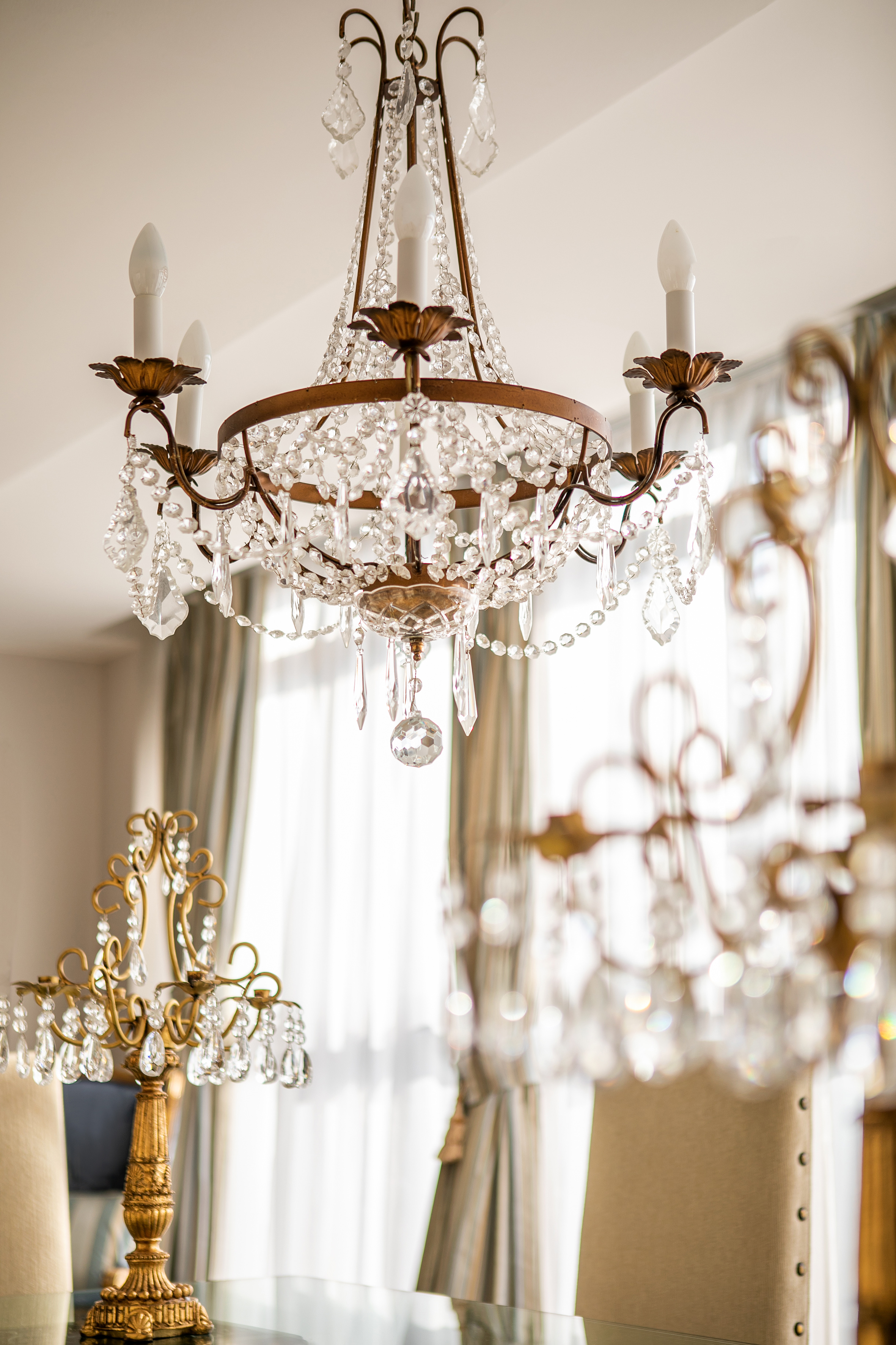 Sparkling crystal chandelier with ornate gold frame and candle bulbs.