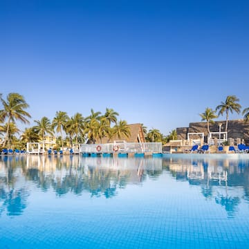 a pool with palm trees and a building