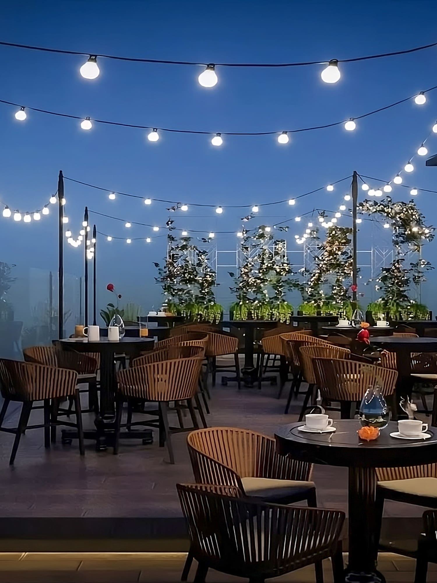 a patio with tables and chairs and string lights