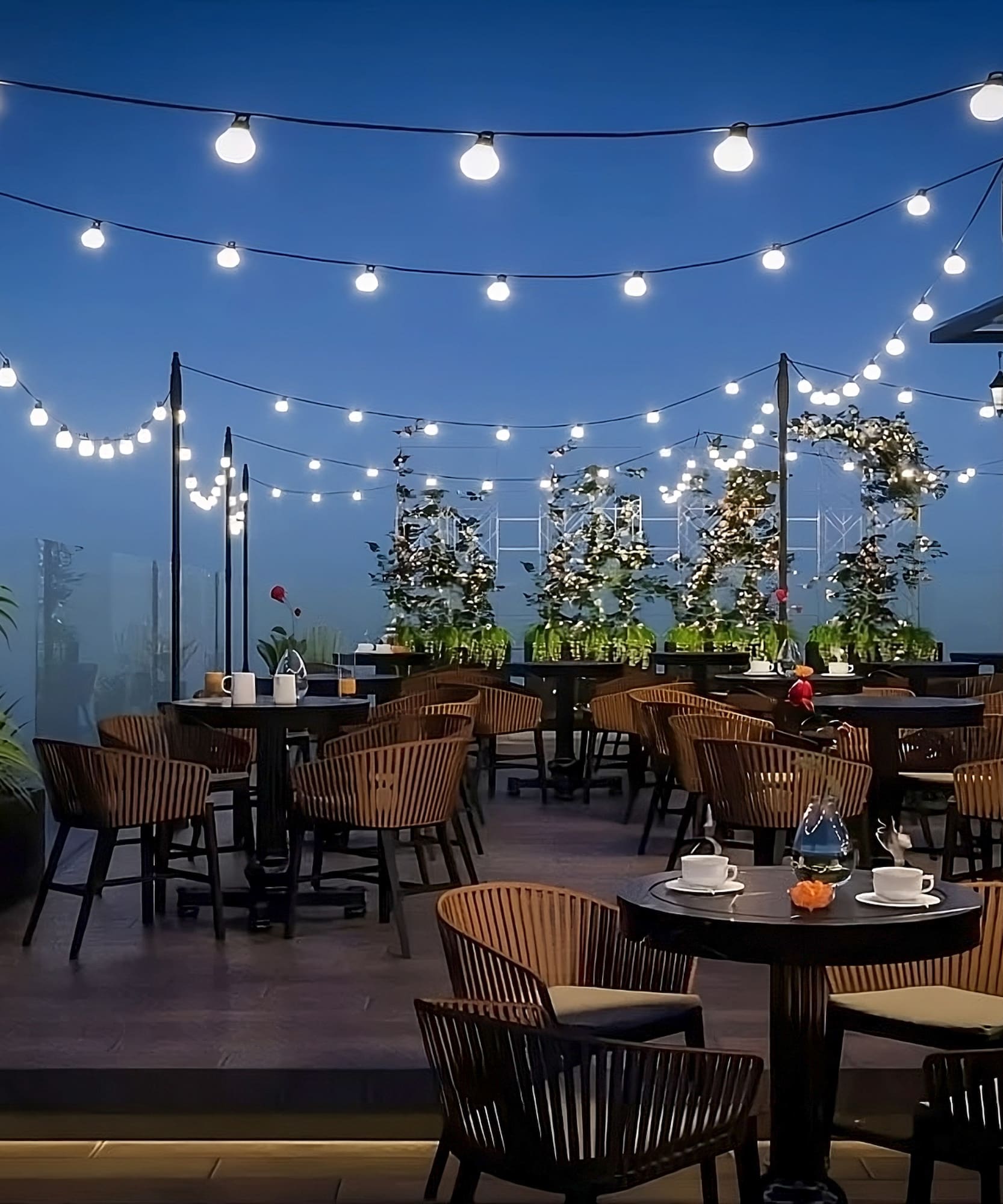 a patio with tables and chairs and string lights
