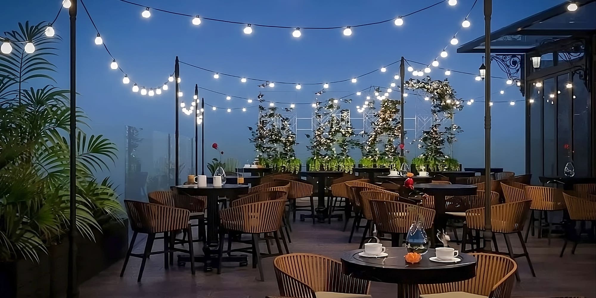 a patio with tables and chairs and string lights