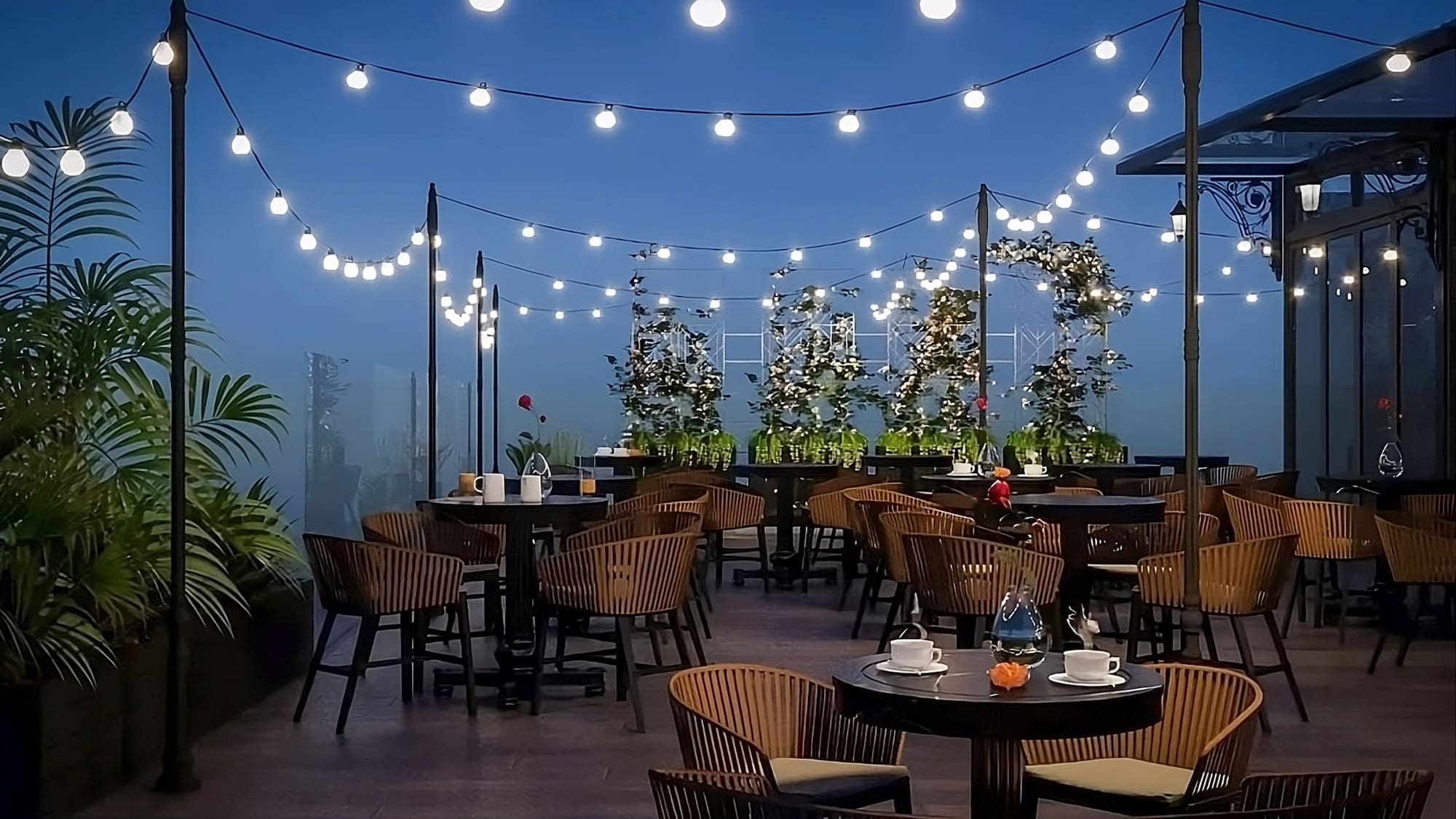 a patio with tables and chairs and string lights