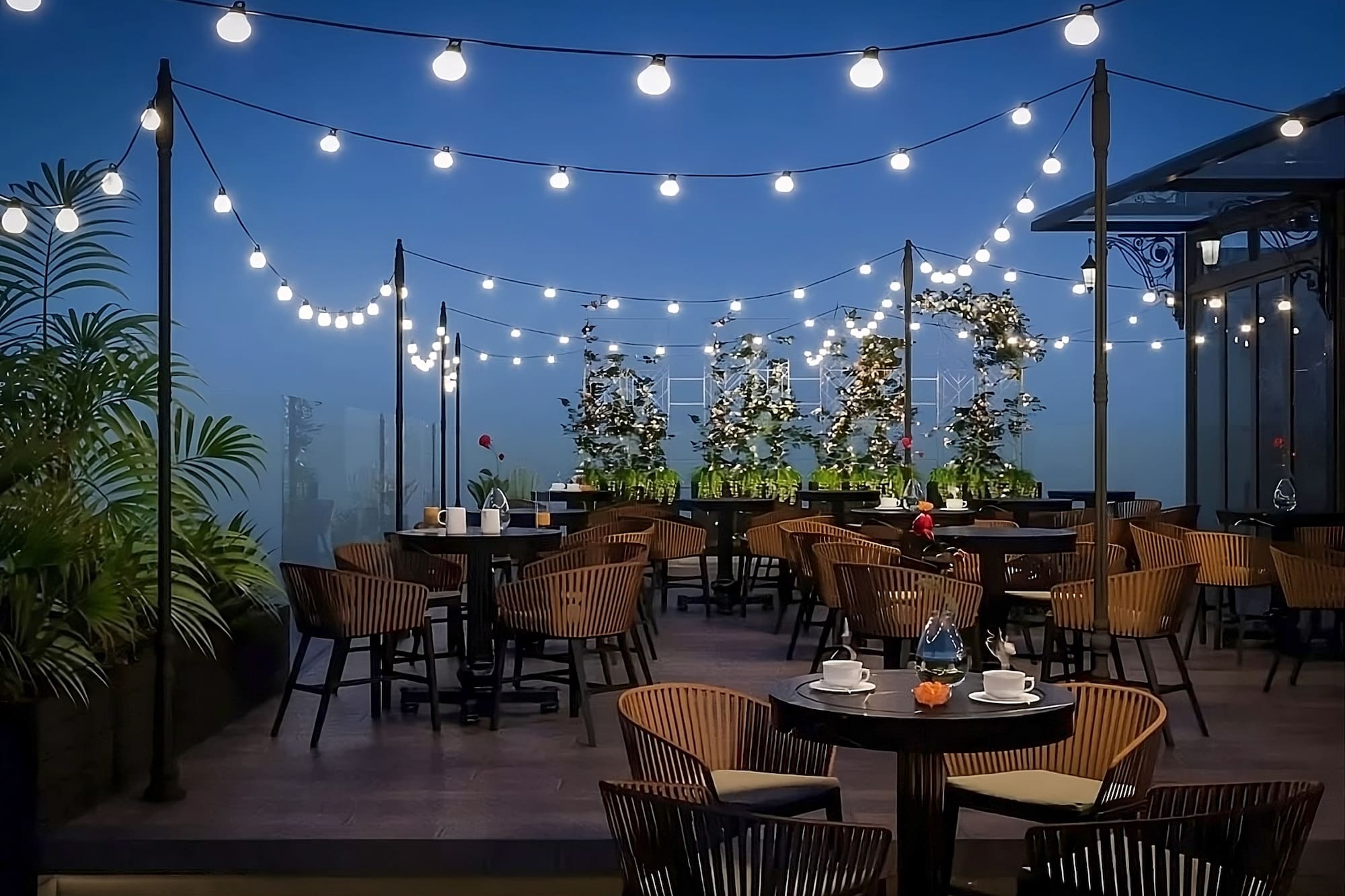 a patio with tables and chairs and string lights