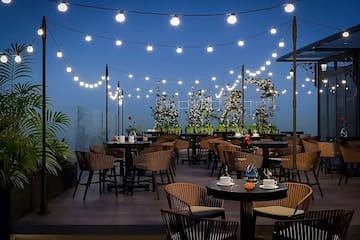 a patio with tables and chairs and string lights