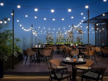 a patio with tables and chairs and string lights