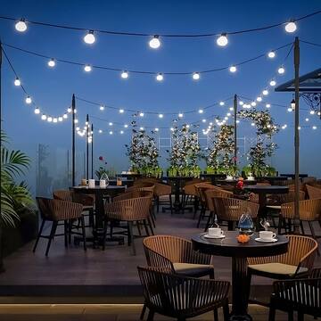 a patio with tables and chairs and string lights