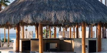 a pool with a thatched roof and a bar