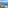 Aerial view: coastal resort, large swimming pool, sunny beach, marina, and green bay.