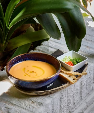 a bowl of soup and a small bowl of bread