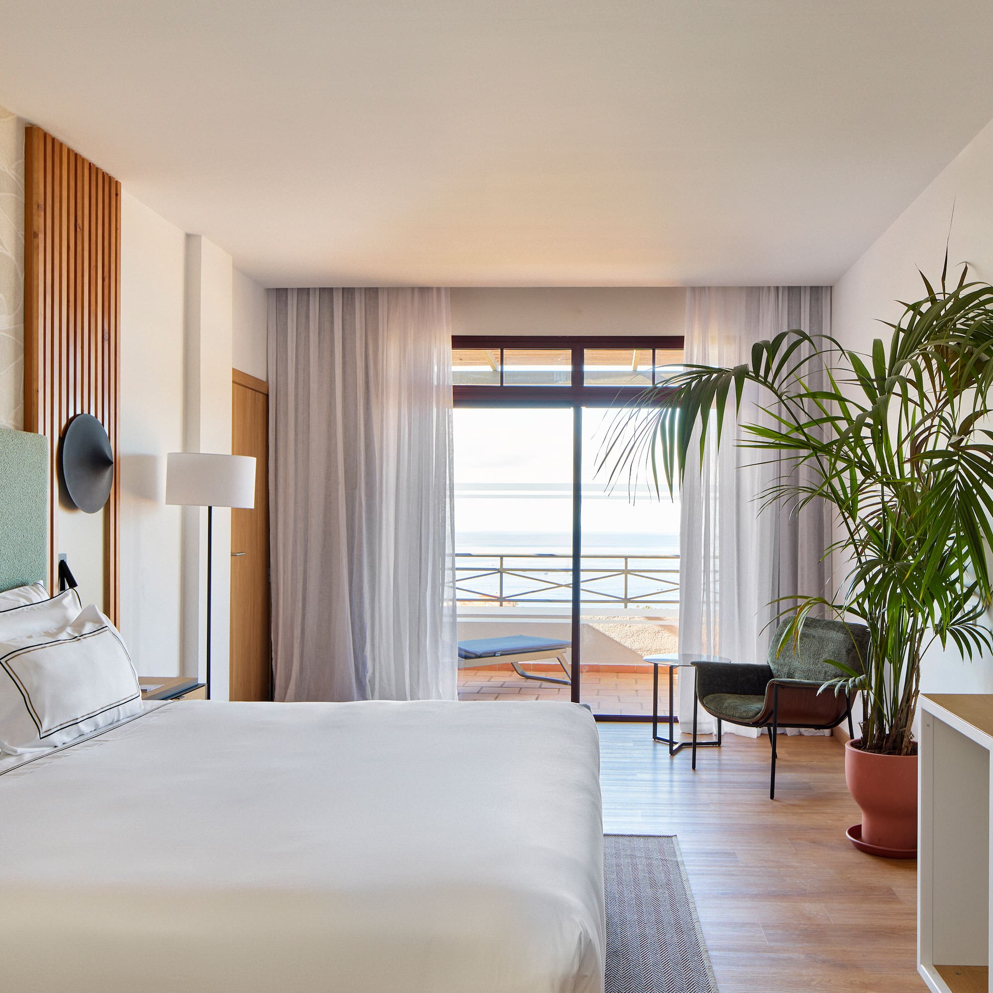 a bedroom with a large bed and a plant