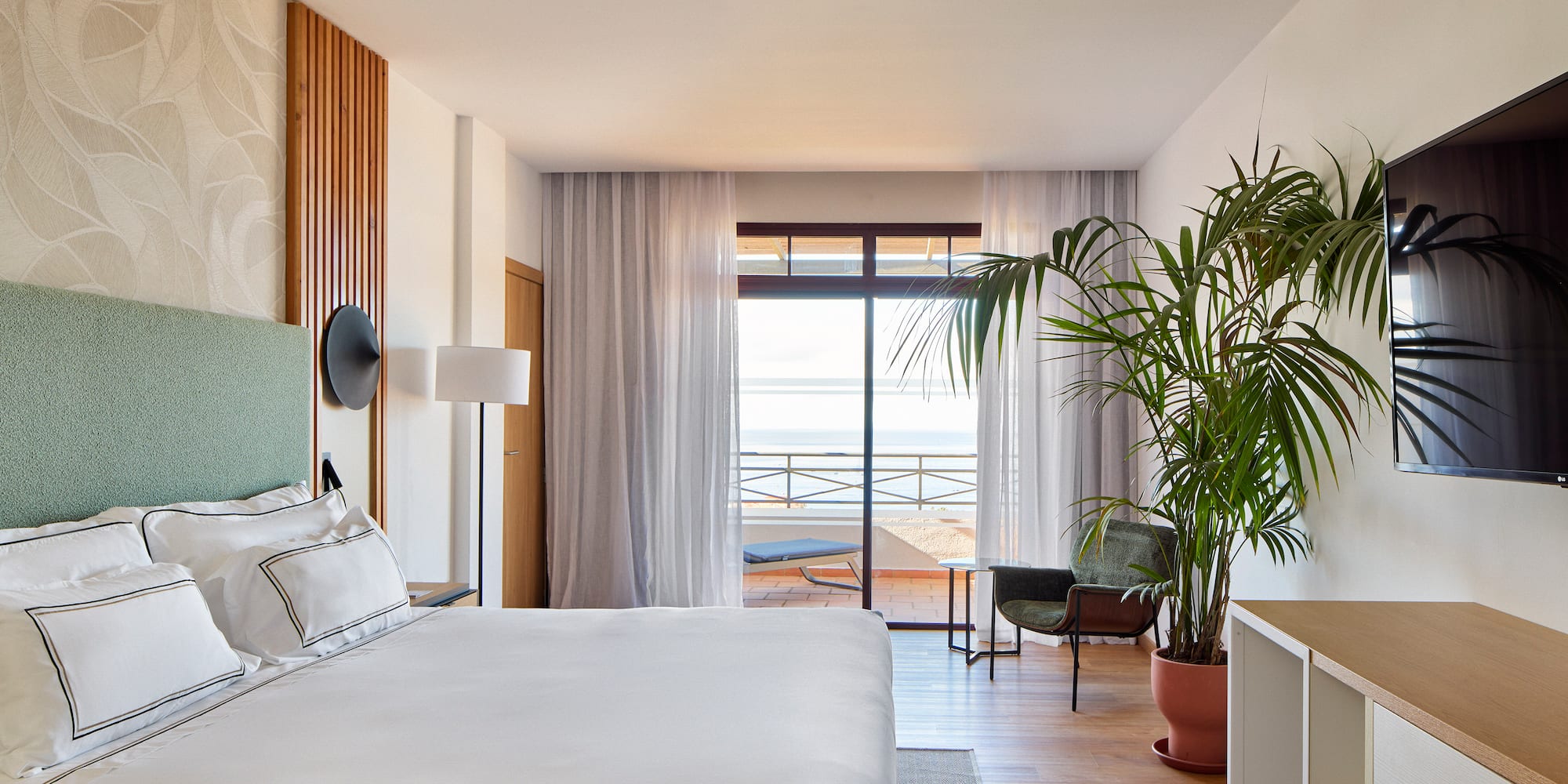 a bedroom with a large bed and a plant